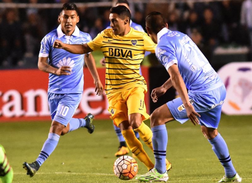El jugador de Bolivar de Bolivia Rudy Cardozo (i) y Ronald Eguino disputan el balon con Federico Carrizo de Boca Juniors de Argentina