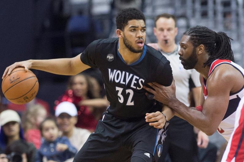 Karl-Anthony Towns (Izq) toca el balón junto al centro de Washington Wizards Nene (der), durante la segunda mitad de la NBA