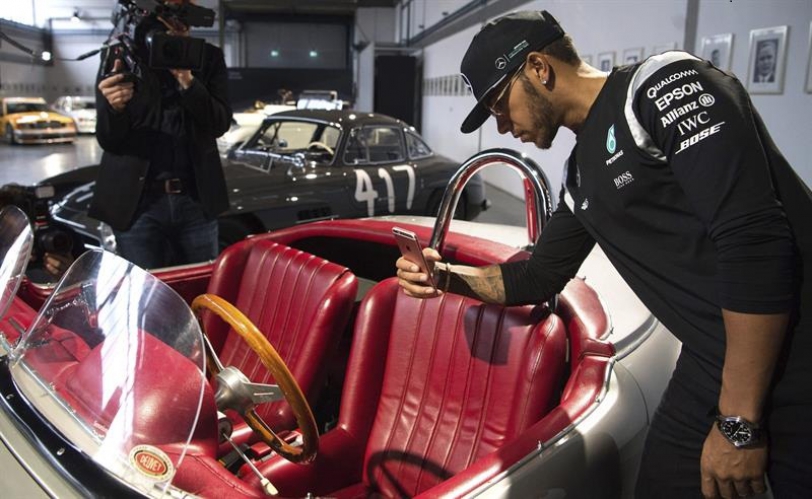 El piloto de Fórmula Uno británico de la escudería Mercedes Lewis Hamilton hace una foto de un Mercedes-Benz 190 SL clásico durante una rueda de prensa con motivo del arranque de la temporada en Fellbach, Alemania, el pasado 11 de marzo de 2016. EFE/Marijan Murat