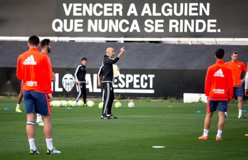 Uno de los técnicos de la planilla valencianista, Pako Ayestarán (centro), da indicaciones a los jugadores del primer equipo que esta tarde han participado en el primer entrenamiento tras las vacaciones de Semana Santa. EFE/Manuel Bruque.