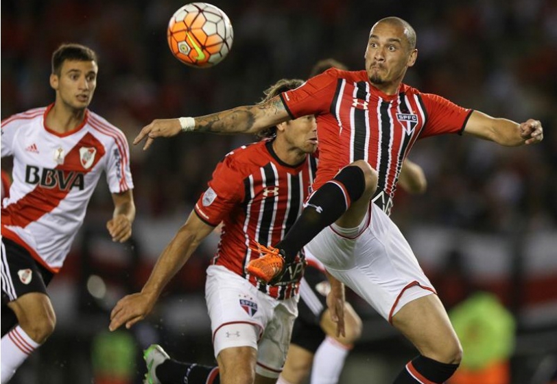 El jugador Emanuel Mammama de River Plate disputa el balón con el jugador Eugenio Mena de Sao Paulo de Brasil