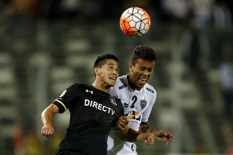 El jugador de Colo Colo, Juan Delgado (i), disputa el balón con Marcos Rocha (d) de Atlético Mineiro