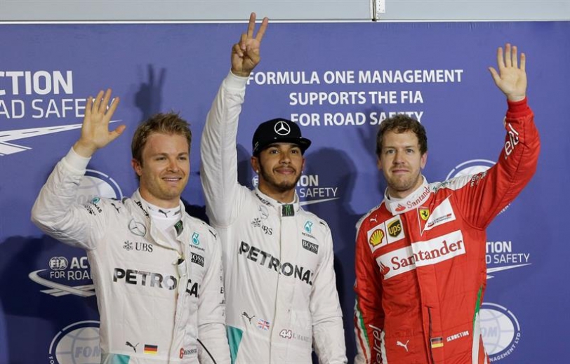 El piloto Británico de Fórmula Uno Lewis Hamilton, de Mercedes AMG GP (C), El piloto de Fórmula Uno de Alemania Nico Rosberg de Mercedes AMG GP (Izq) y el alemán de Fórmula Uno Sebastian Vettel de la Scuderia Ferrari (Der) celebra después de la sesión de clasificación de la Fórmula Bahrain Uno Gran Premio en el circuito de Sakhir cerca de Manama, Bahrein, 02 de Abril el año 2016